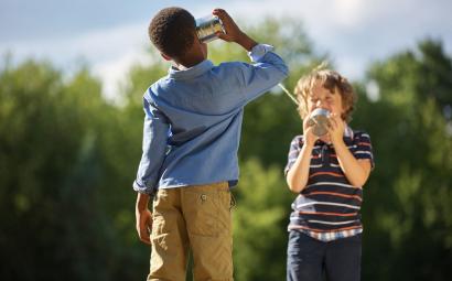 Kinderen die blikjes vasthouden om met elkaar te communiceren