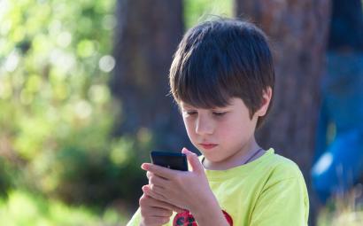 Een kind kijkt naar een smartphone