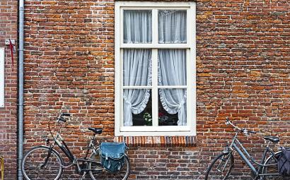Bakstenen muur met raam en fietsen ervoor
