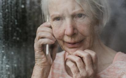 Oudere vrouw kijkt uit het raam