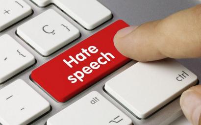 wijsvinger klikt op toetsenbordknopje met hate speech