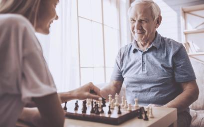 Oudere man schaakt met jongere vrouw