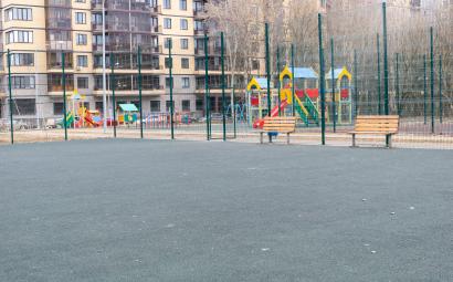 Lege speeltuin omringd door asfalt en flats