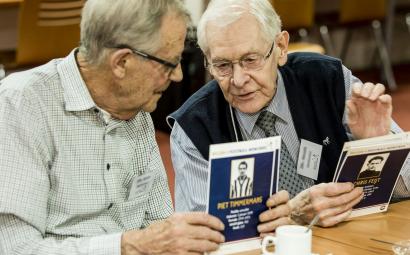 Twee oudere mannen kijken naar oude foto's