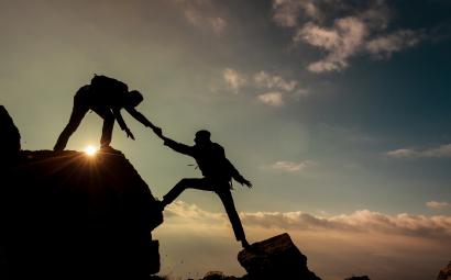 Mensen helpen elkaar tijdens bergwandeling