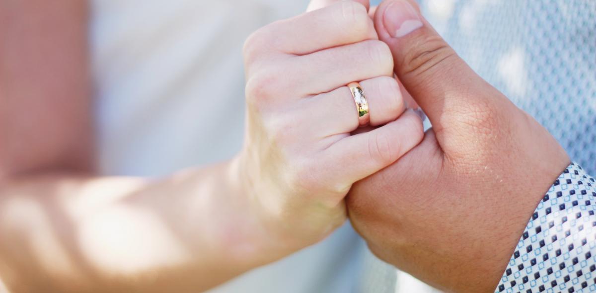 Foto van twee handen en een trouwring