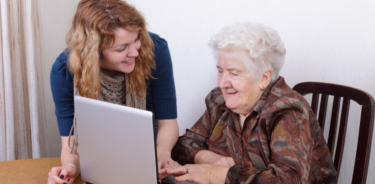 Oudere achter laptop met uitleg