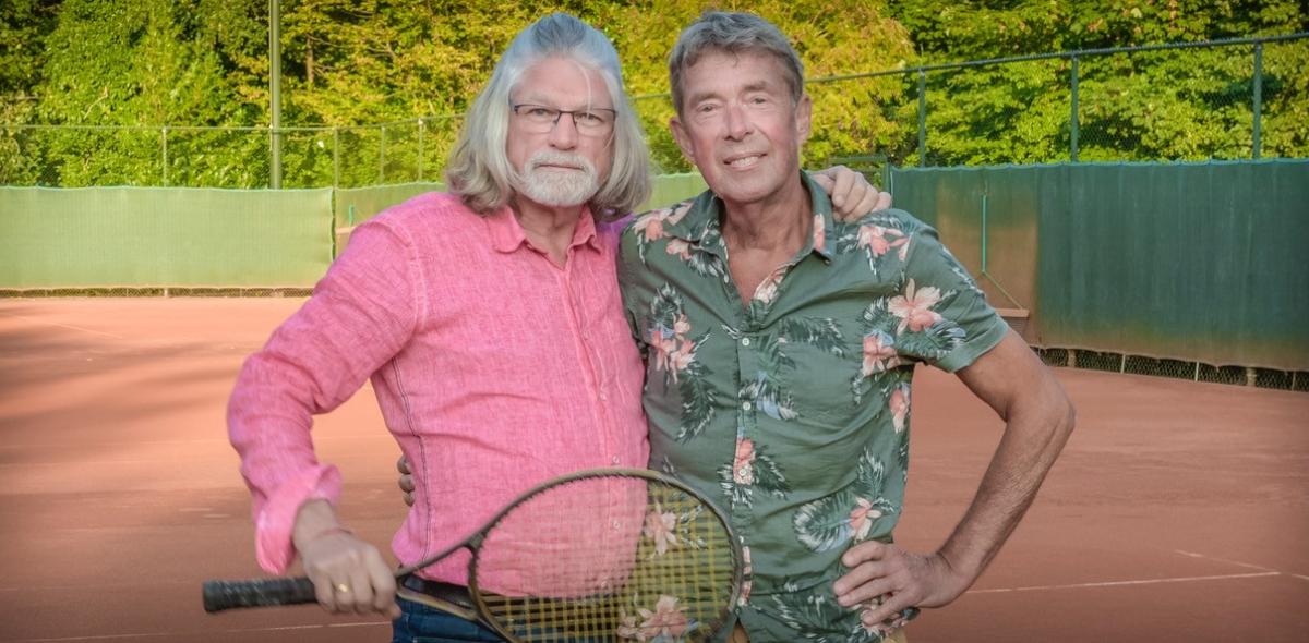 Ed en Tom op de tennisbaan met een tennisracket in hun hand